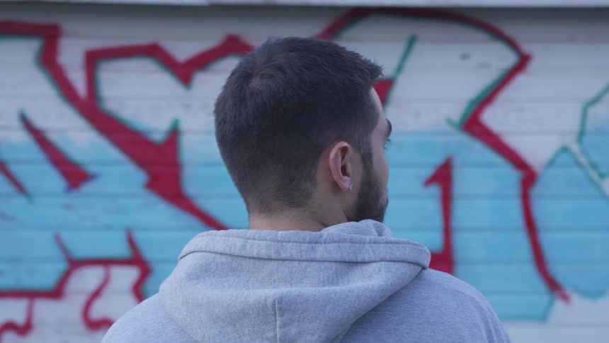 Man with hoodie stare at the gravity on the wall