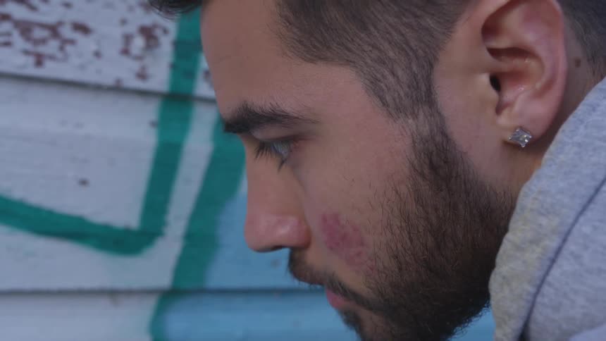 A man face looking down and staring at something