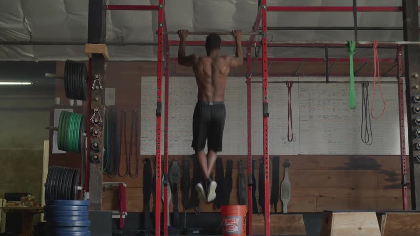 Man does chin ups in gym