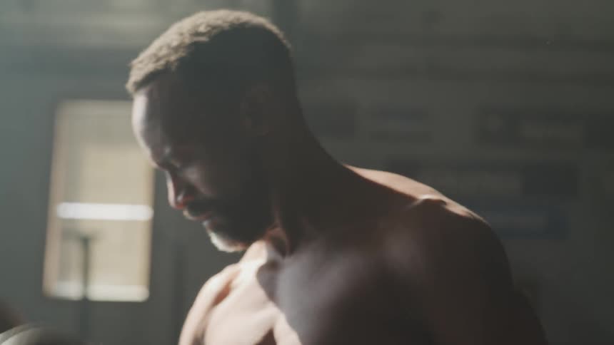 A man is lifting weights indoors