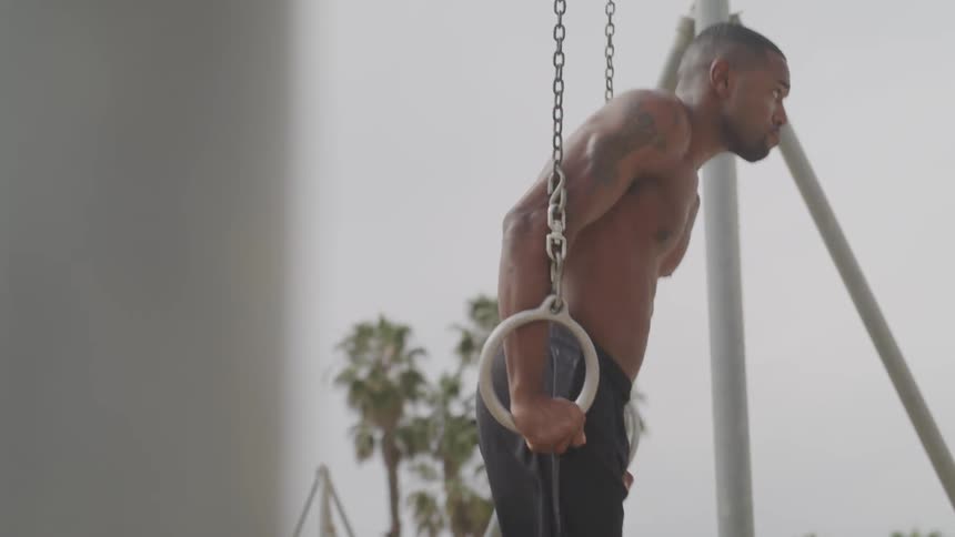 Man using the rings in a park