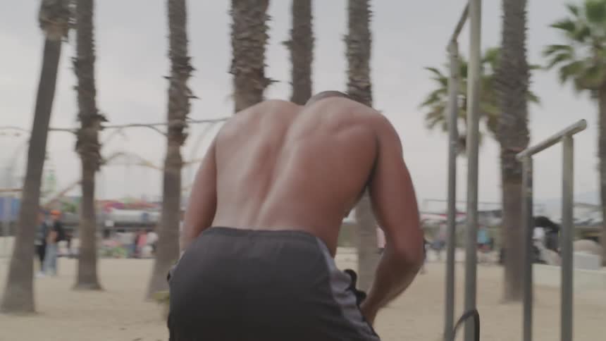 A man doing rope exercises on the beach