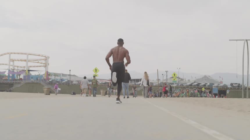A young man runs through a crowded park