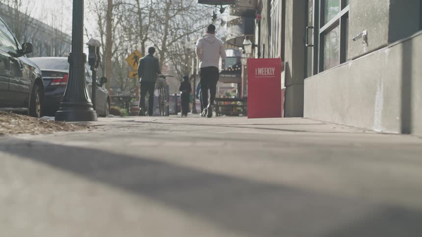People are jogging and walking down the sidewalk