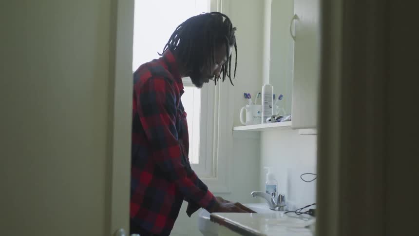 Man leans on the sink in the bathroom