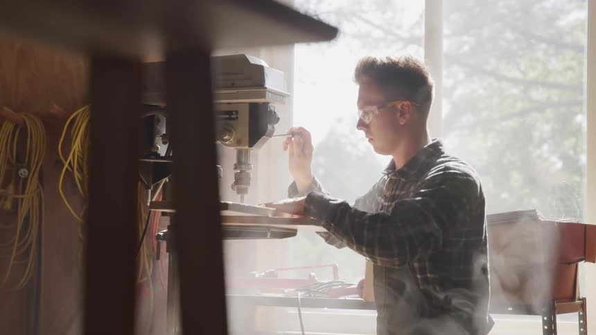 Man uses woodworking machinery on board