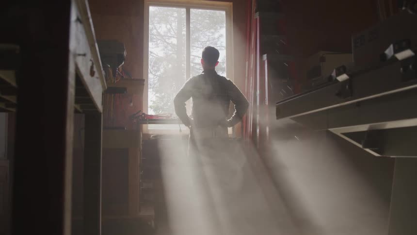 Man looks out the window while the sun streams through