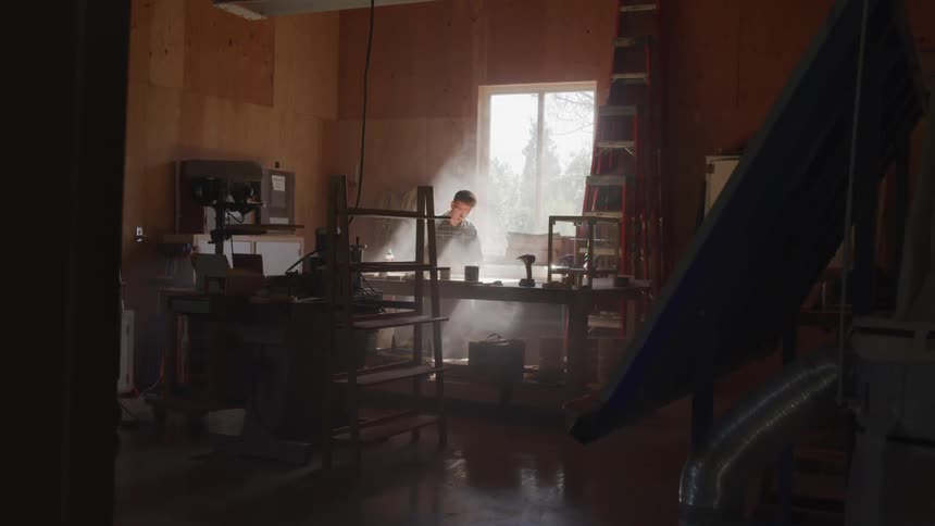 A man works with tools in an indoor workshop