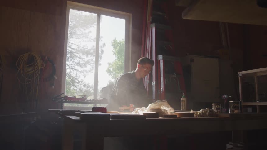 A man works at a table in a workshop