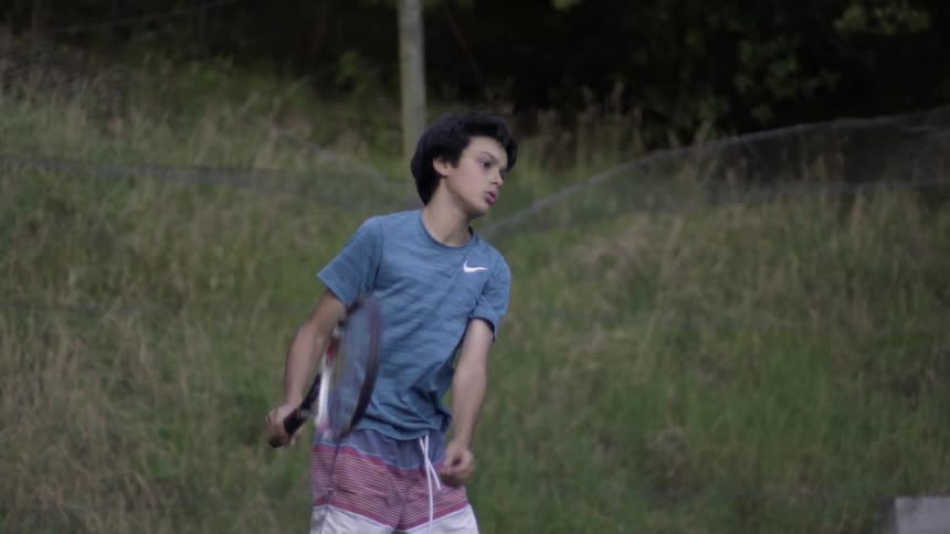 Young Boy Playing Tennis Outdoors on Court — Sunny Day Sports Action Footage Clip.
