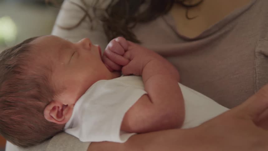Mother carrying and swinging her toddler to sleep