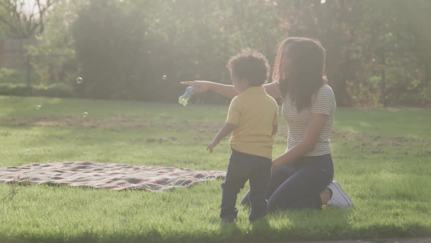 Mother blowing bubbles with her son