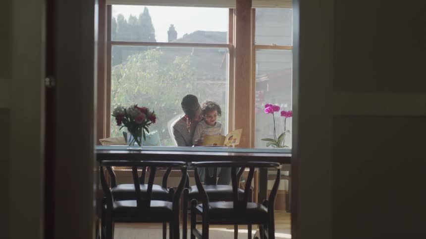 Mom and son reading a book at the table