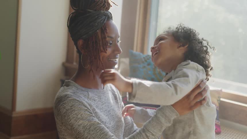 Mother and daughter smiling and playing at home