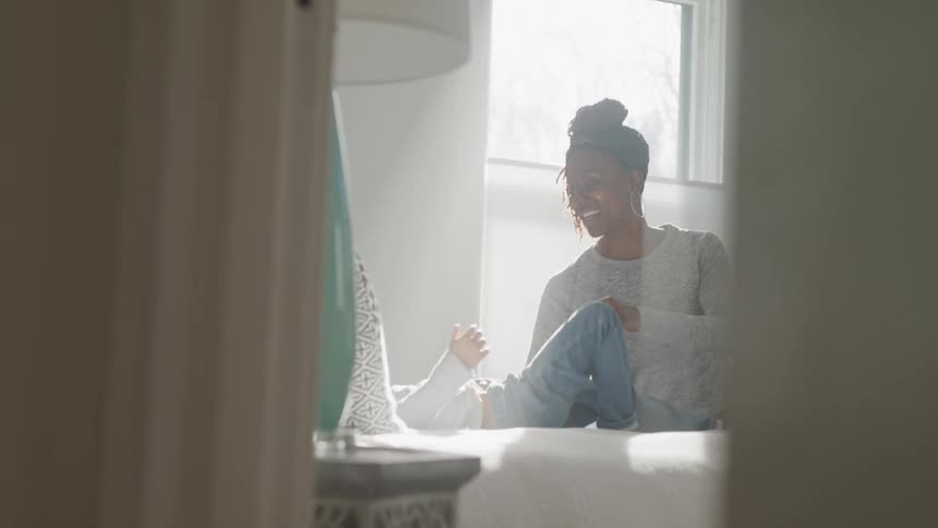 Woman playing with her child in bed