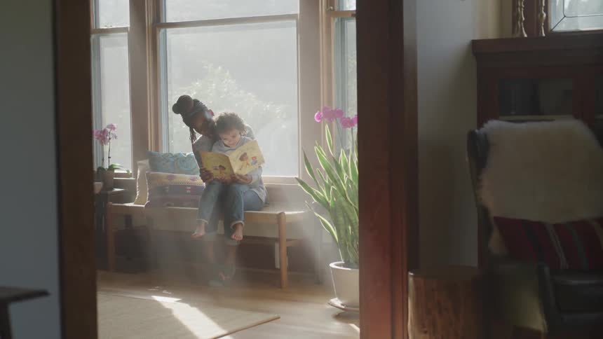 A mother and son sitting down reading a book