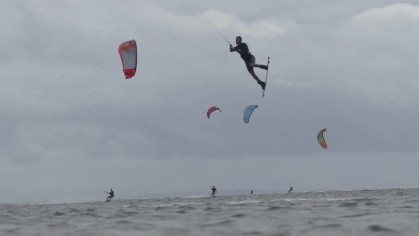 A person rides a wakeboard across the surface of the water as a boat pulls them along.