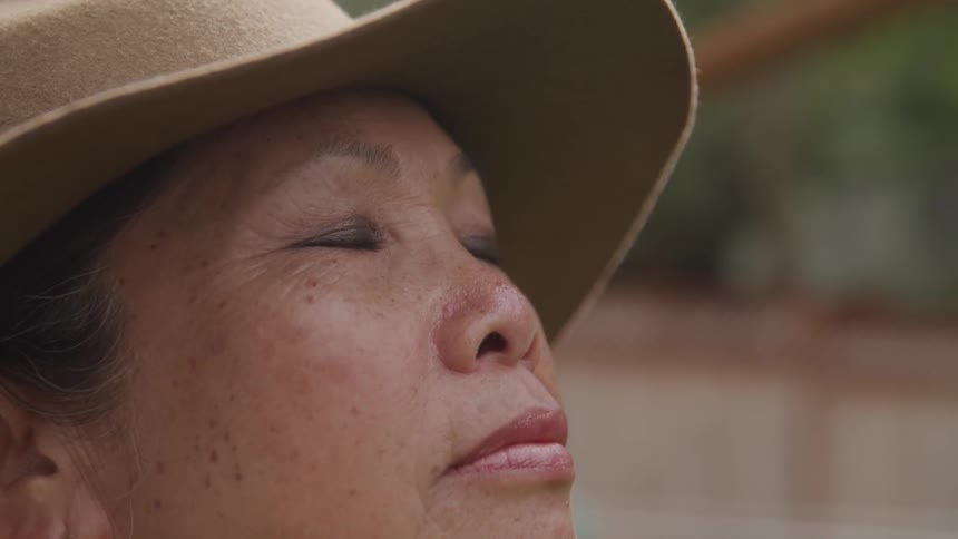 An elderly asian woman with her eyes closed