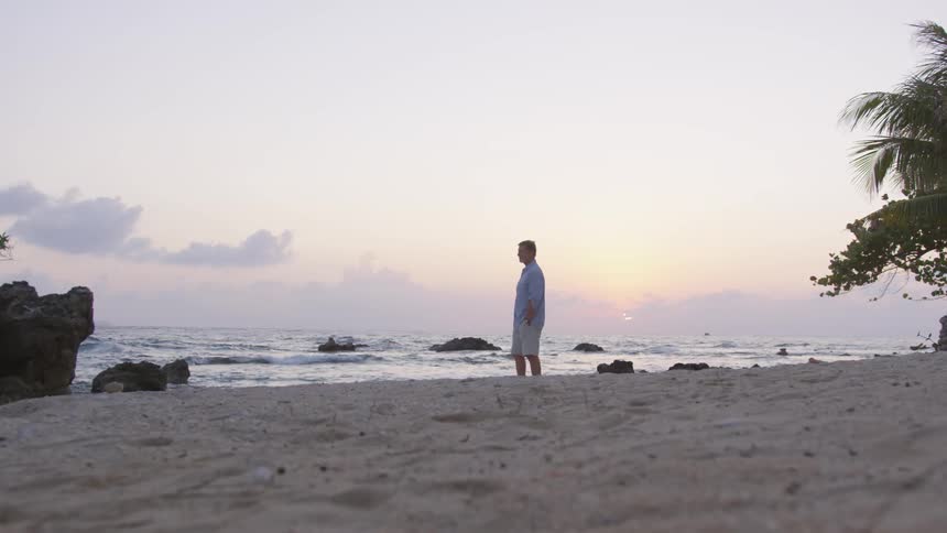 A man walks down by the water
