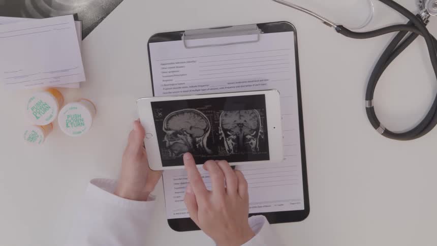 Person in lab coat pages through x rays