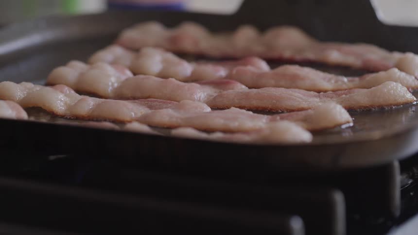 Bacon is being cooked indoors