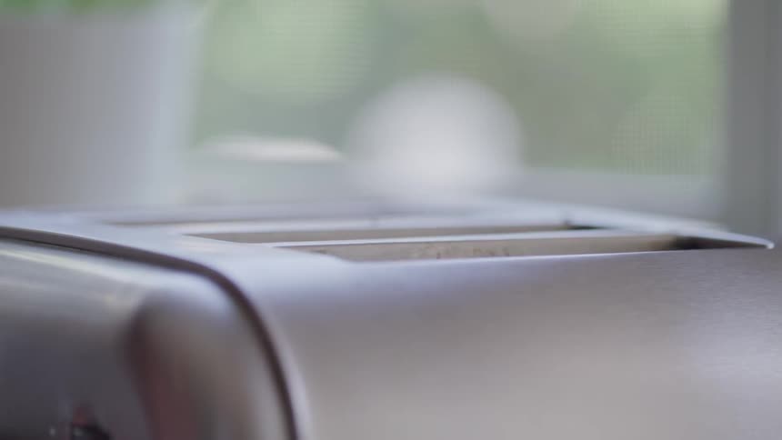Toast pops up from the toaster in a bright kitchen