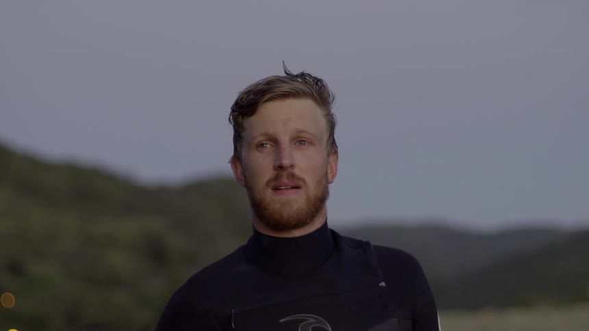 A man looks off into the distance and blinks, pausing in a moment of contemplation or observation.