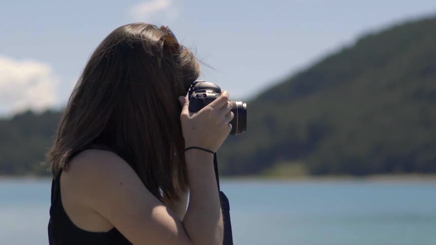 A woman is taking photographs on a sunny day