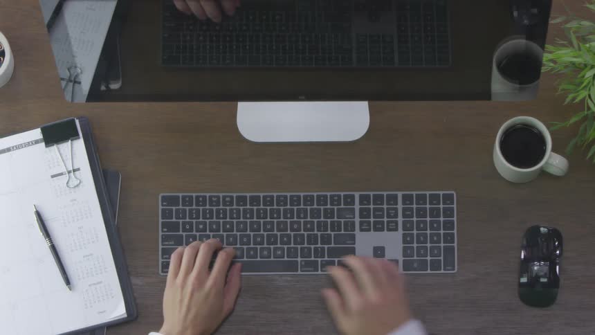 A man typing on a keyboard at desk