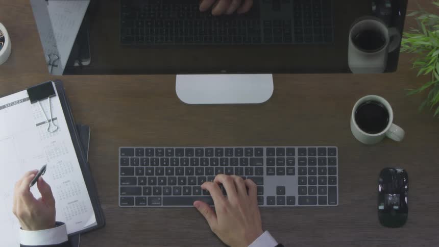 A man worker typing on an apple keyboard