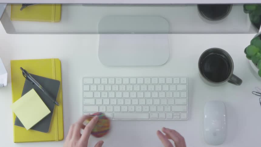 Male typing in a keyboard before playing with a rubber band ball