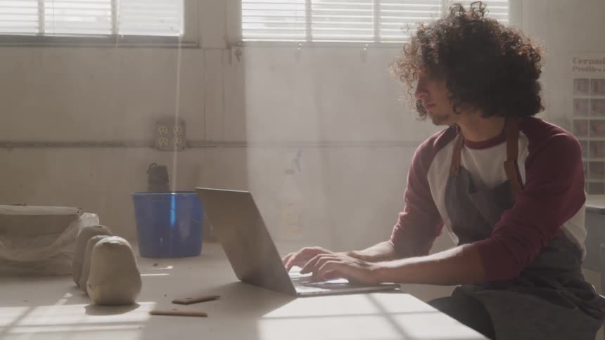 A man types on a laptop on a table