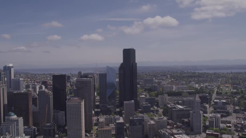 Tall buildings in a city sit under a blue sky