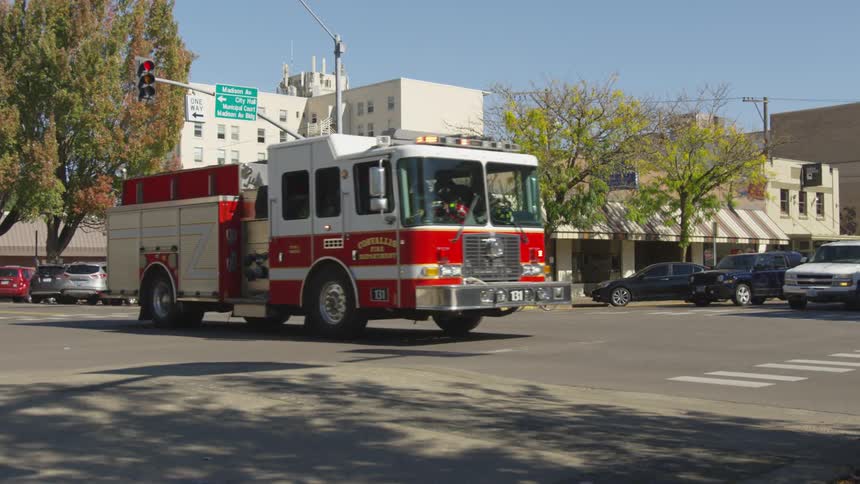 A fire truck drives through an intersection