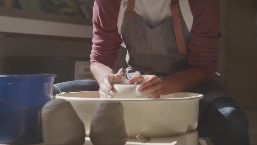 A man is spinning clay using a machine