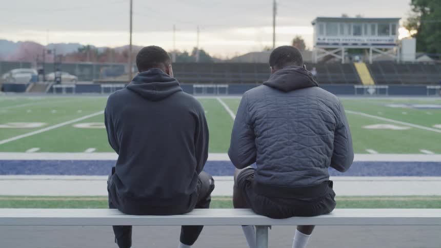Black males sitting on a bench