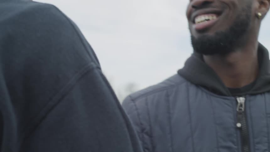 A pair of men greeting one another on an athletics track