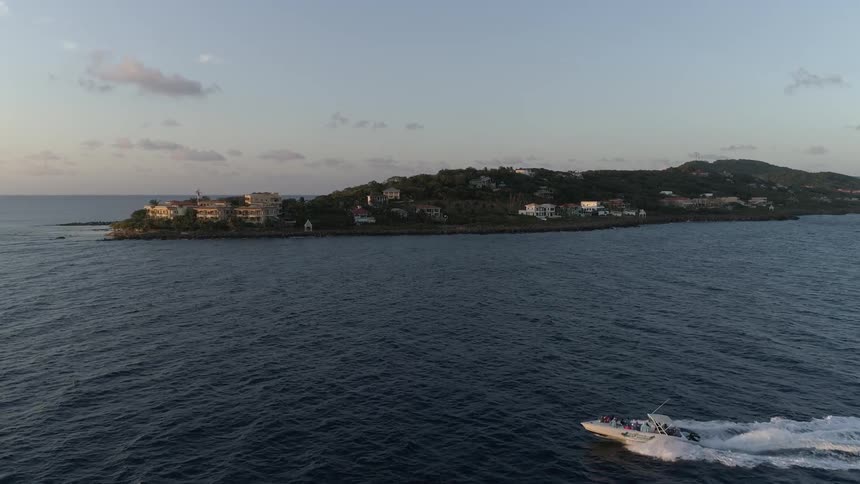 A boat in the ocean with a peninsula in the background