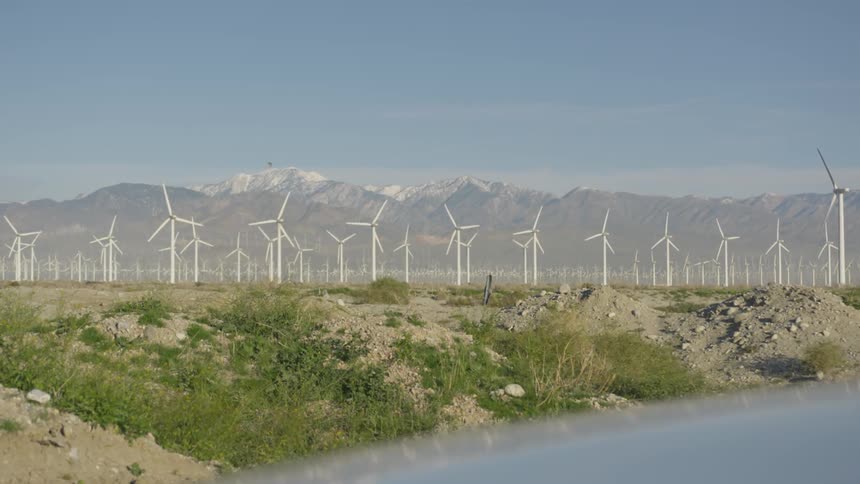 A turbines spinning on a wind farm during the day