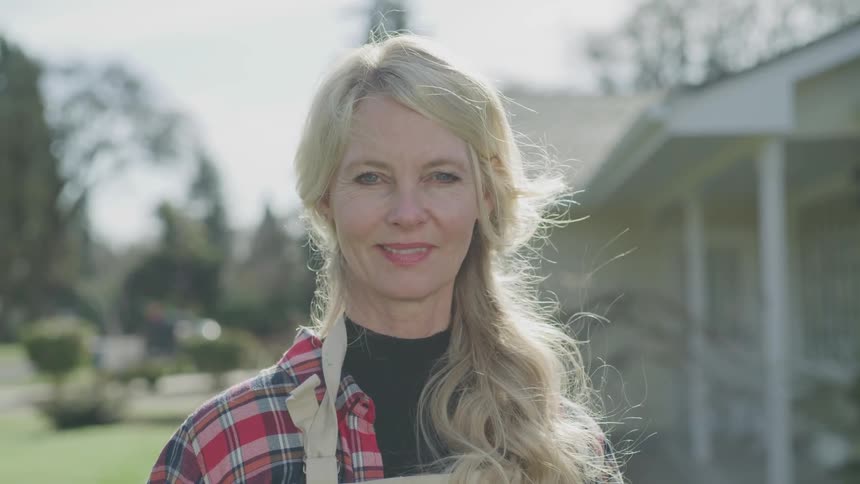 A woman is standing outside smiling