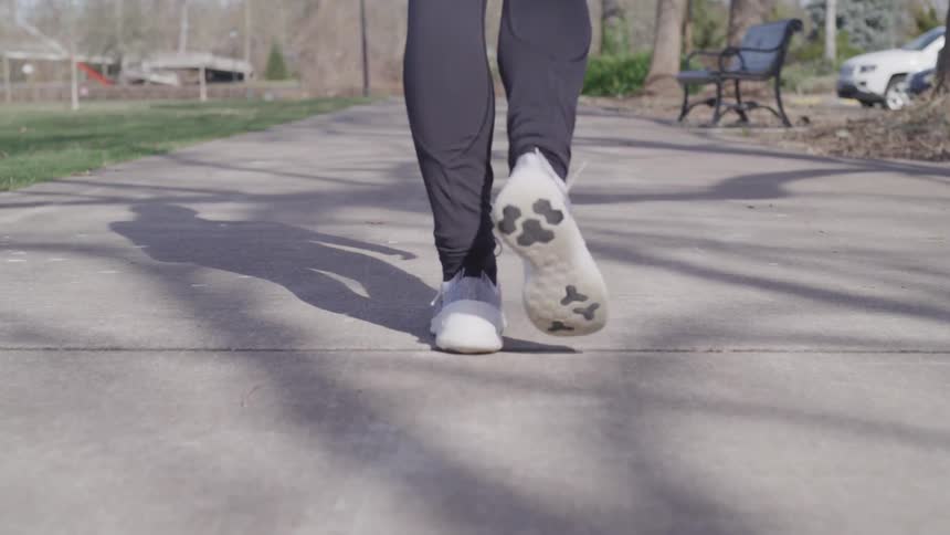 A man walks down a paved trail