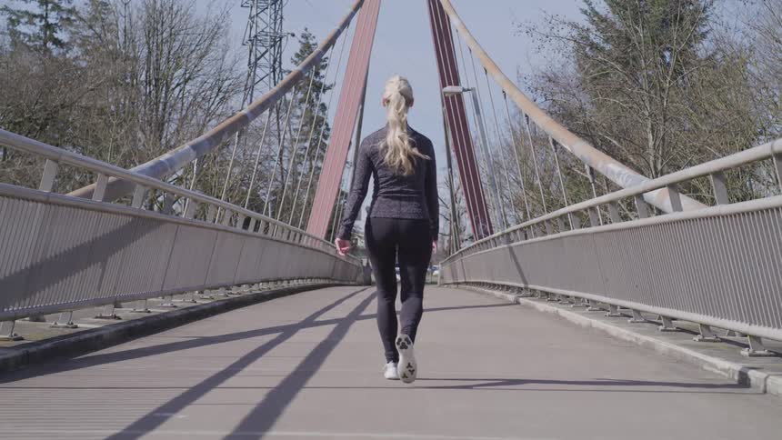 Girl walking across a bridge