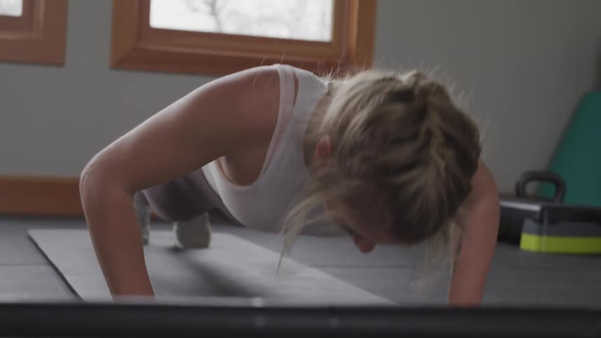 A woman doing push ups in a gym