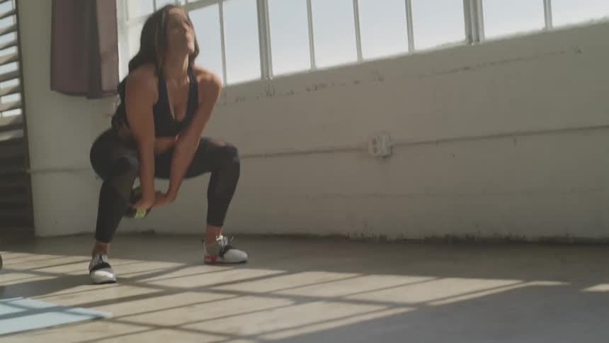 A woman exercising with a kettle bell