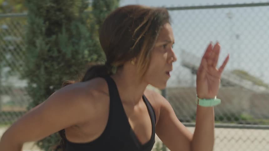 A woman is doing exercises outdoors and jogging