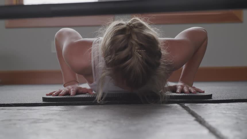 A young woman doing push ups on a mat