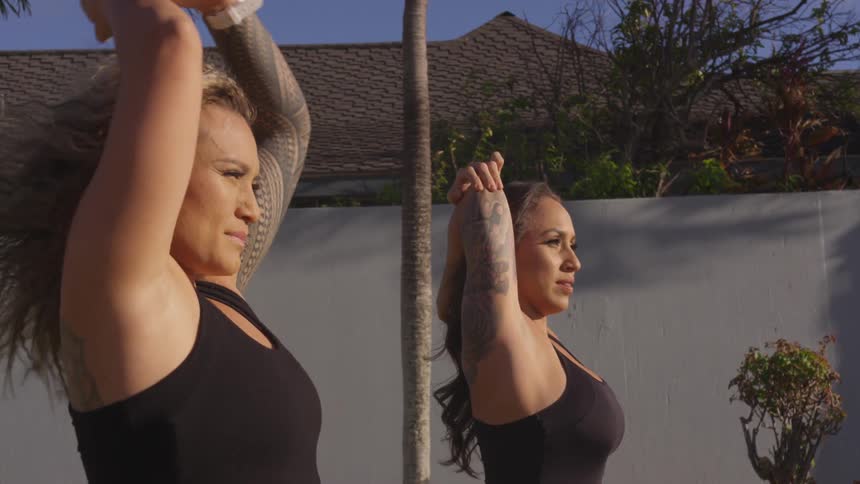 Two women stretch outside