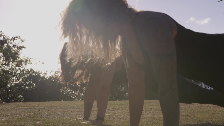 Two women do push ups on the grass
