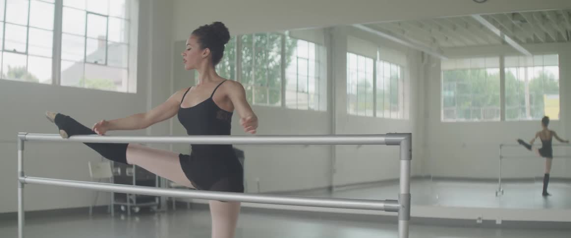 A dancer stretches at a bar