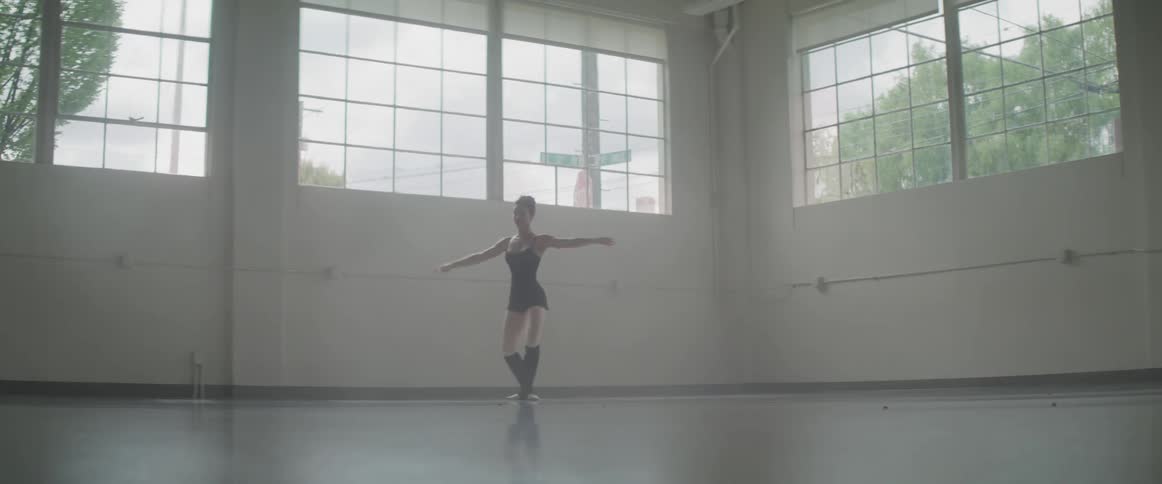 Woman dances in a room during daylight
